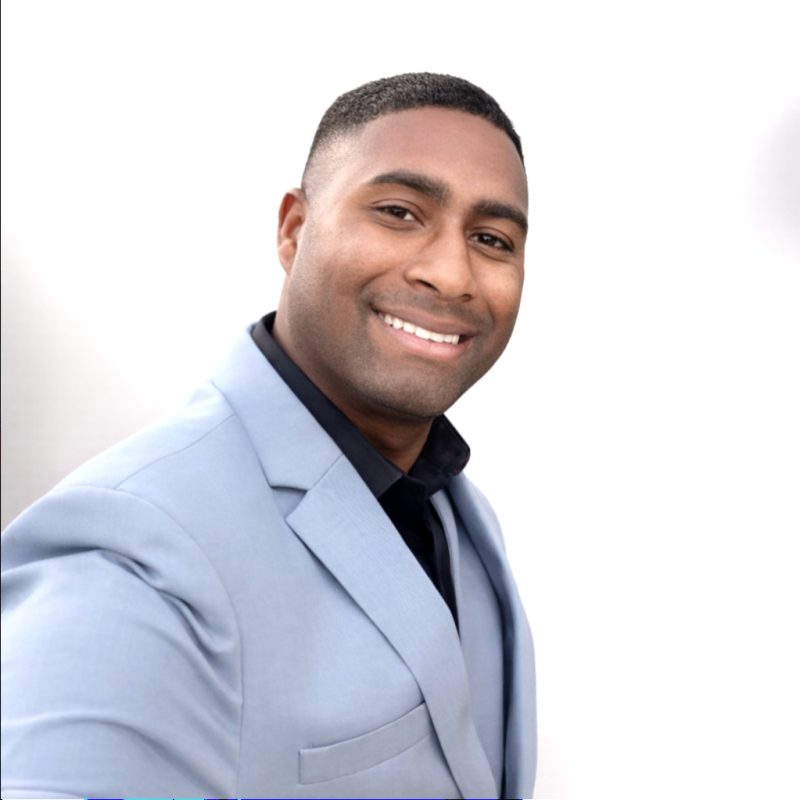 Marquise, owner and driver of ProEliteDrivers, smiling in a light blue suit